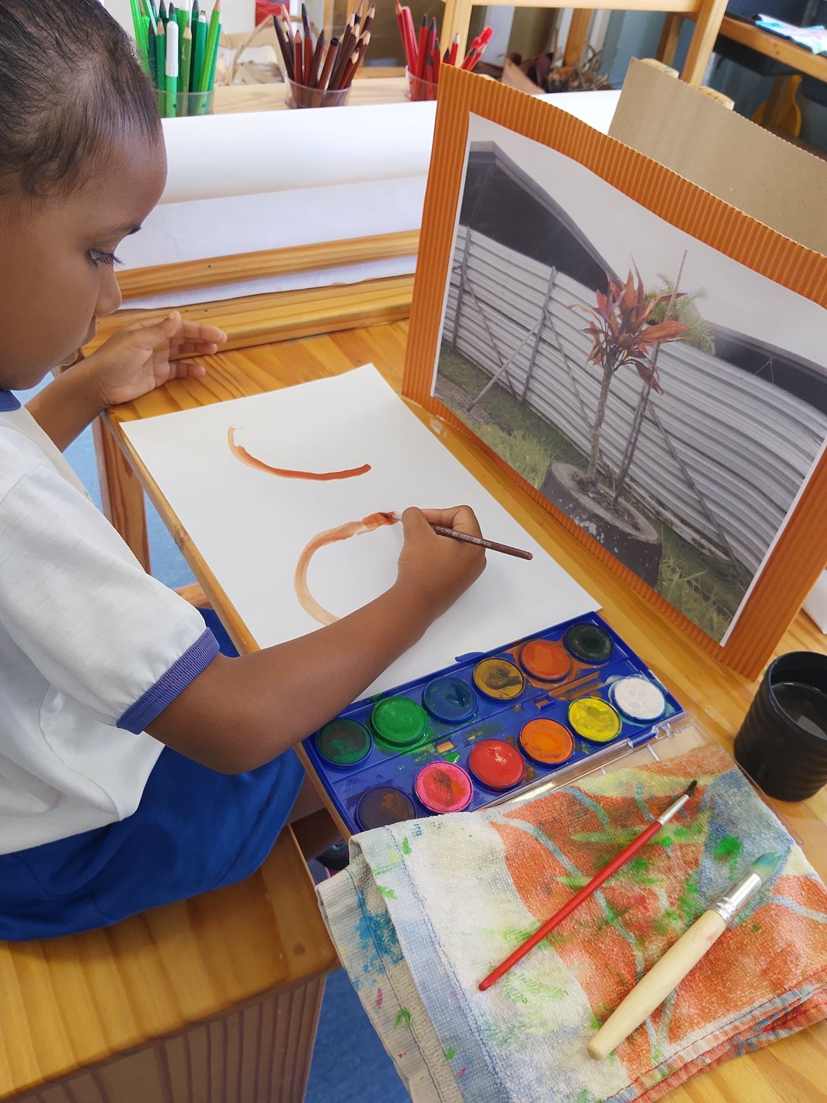 Criança pintando com aquarela a partir de uma fotografia